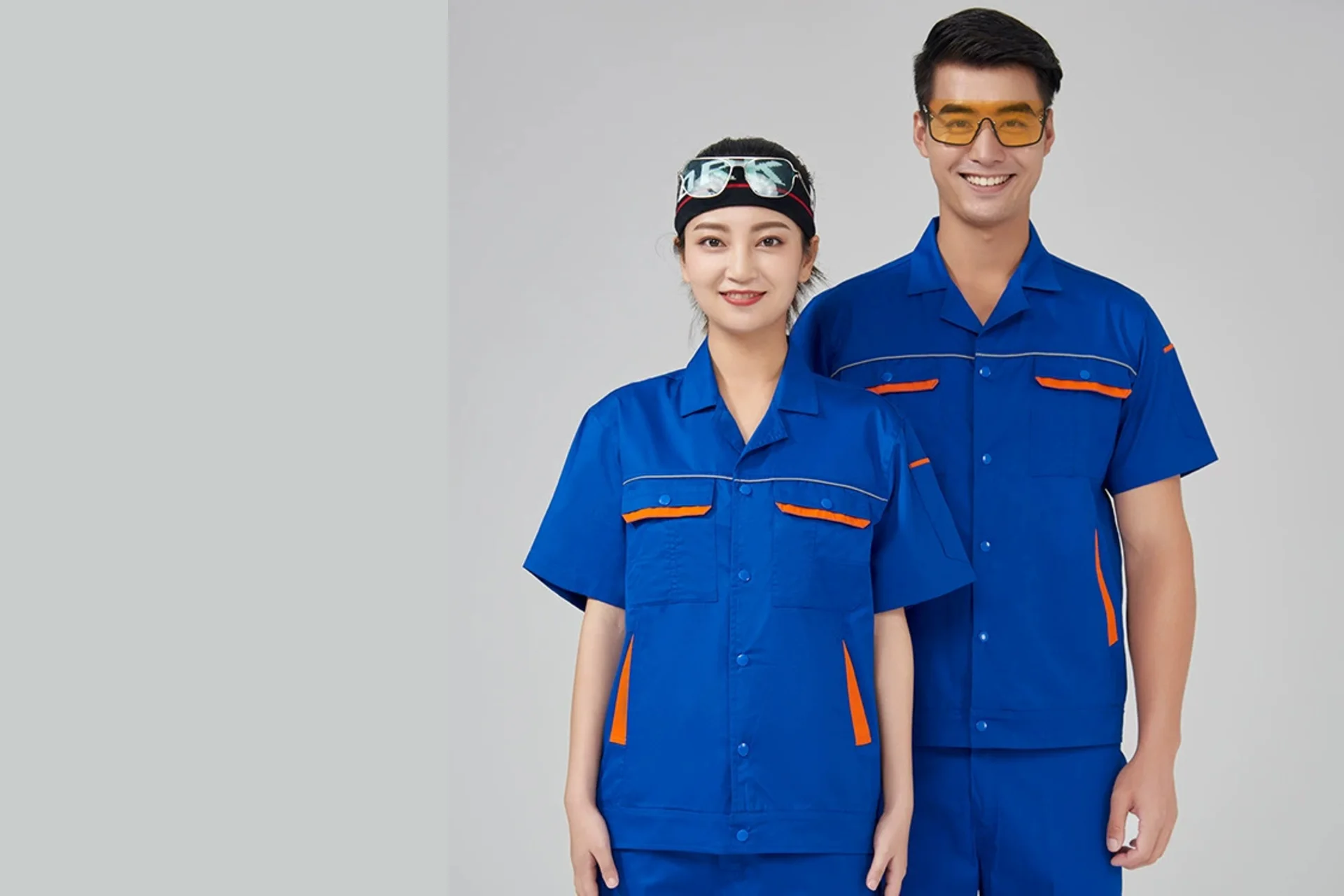 身着蓝色企业工作服的两位成衣模特，展示工作服版型与拼色细节